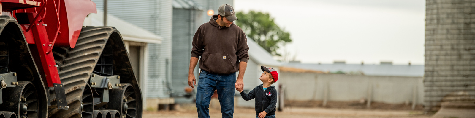 Father and son by farm machinery